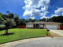 Inviting single-story home boasts a well-manicured lawn and tasteful stone accents at 10305 Worthy Lamb Way, New Port Richey, FL 34654