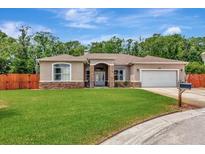 Charming single story home with a lush green lawn and an attached two car garage at 10305 Worthy Lamb Way, New Port Richey, FL 34654