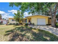 Charming yellow single-story home featuring an attached one car garage and mature landscaping at 11376 119Th Ter, Largo, FL 33778