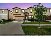 Charming two-story home showcasing a well-manicured lawn and neutral-toned exterior with a two car garage at 12643 Horseshoe Bend Dr, Lithia, FL 33547