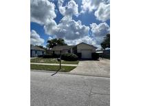 Charming single-story home featuring a well-maintained lawn, an attached garage and inviting curb appeal at 1332 Fuchsia Dr, Holiday, FL 34691