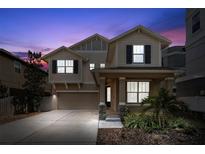 Inviting two-story home featuring a cozy front porch and well-manicured landscaping at twilight at 1520 W Fig St, Tampa, FL 33606