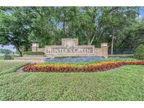 Community entrance sign for Hunter's Green amid colorful flowerbeds and lush landscaping at 18108 Ashton Park Way, Tampa, FL 33647