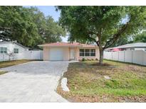 Charming single-story home featuring a paver driveway and lush landscaping, creating great curb appeal at 3303 W Ballast Point Blvd, Tampa, FL 33611