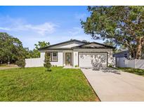Charming single-story home with a well-manicured lawn, attached garage, and classic white exterior at 331 Archimedes St, Dunedin, FL 34698
