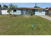Charming single-story home with light blue exterior and a spacious front yard at 4506 Eden Rock Rd, Tampa, FL 33634