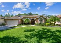 Charming single story home featuring mature landscaping, a tile roof, and a two-car garage at 5027 Cross Pointe Dr, Oldsmar, FL 34677