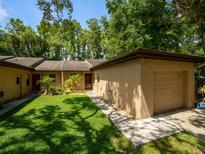 Charming home exterior featuring well-maintained lawn, attached garage, and mature trees at 6201 Amaretto Ln # 6201, Tampa, FL 33634