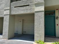 Exterior shot of condo with garage and green front door set in stucco wall at 622 Seascape Way, Tampa, FL 33602