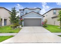 Charming two-story home featuring a well-maintained lawn and attached two car garage at 6384 Ten Acre Ct, Zephyrhills, FL 33541