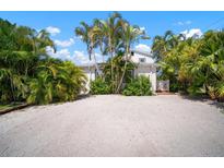 Charming white home surrounded by lush tropical landscaping and a shell driveway at 656 40Th Ne Ave, St Petersburg, FL 33703