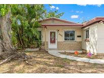 Charming single-story home with well-kept lawn, large tree, and inviting front entrance with colorful decorations at 6982 78Th N Ave, Pinellas Park, FL 33781