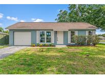 Charming one-story home with a well-manicured lawn, attached garage, and shuttered windows at 7400 Belvedere Ter, New Port Richey, FL 34655