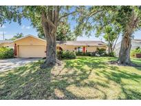 Charming single-story home with a well-maintained lawn and mature trees at 8956 124Th Way, Seminole, FL 33772