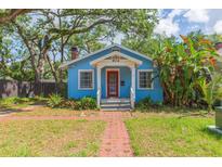 Charming blue single-story home with a red front door and a brick walkway at 904 E Patterson St, Tampa, FL 33604