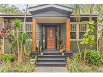 Charming front porch with wood columns and decorative plants, creating a welcoming entrance to the home at 916 E Broad St, Tampa, FL 33604