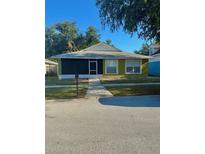 Charming single-story home with a green lawn and an enclosed front porch at 10411 Summerview Cir, Riverview, FL 33578