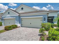 Charming home with a two-car garage and well-maintained landscaping featuring bushes and a paved driveway at 12817 Cobalt Ter, Bradenton, FL 34211