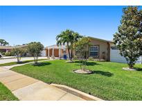 Charming single-story home featuring a lush lawn with beautiful landscaping and curb appeal at 13035 91St Ave, Seminole, FL 33776