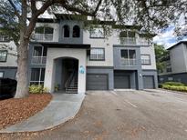 Condo exterior with gray paint, private garages, and balconies offers modern living at 13243 Sanctuary Cove Dr # 204, Temple Terrace, FL 33637