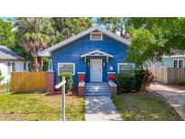 Charming blue bungalow with a welcoming front porch and well-manicured lawn, offering classic curb appeal at 207 W Chelsea St, Tampa, FL 33603
