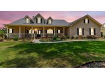 Charming single-Gathering home featuring a covered front porch, inviting curb appeal, and lush landscaping at 2202 Colewood Ln, Dover, FL 33527