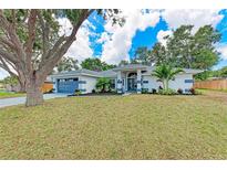 Beautiful single-story home featuring a well-manicured lawn, complemented by mature trees and decorative landscaping at 3330 46Th E Ter, Bradenton, FL 34203