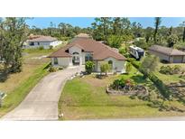 Well-manicured lawn and landscaping accent this charming single Gathering home with a curved driveway at 3610 Woodbridge Ave, North Port, FL 34287