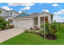 Charming single-story home featuring a two-car garage and a well-manicured lawn with lush landscaping at 5492 Summer Sunset Dr, Apollo Beach, FL 33572