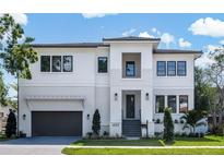 Modern two-story home with white siding, black-framed windows, and well-manicured lawn at 620 Marmora Ave, Tampa, FL 33606
