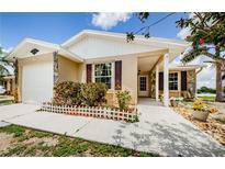 Charming single-story home with tan siding, stone accents, and a well-maintained front yard and walkway at 699 Merlins Ct, Tarpon Springs, FL 34689