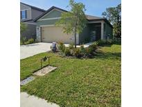 Charming single-story home with a well-manicured lawn and a two-car garage at 10607 Ladybug Cv, Parrish, FL 34219
