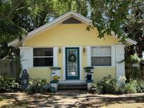 Charming yellow home featuring a teal door and landscaped front yard at 132 21St S Ave, St Petersburg, FL 33705