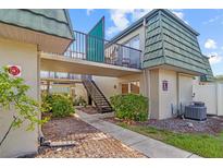 Charming condo building featuring well-maintained landscaping and exterior stairs at 1799 N Highland Ave # 180, Clearwater, FL 33755