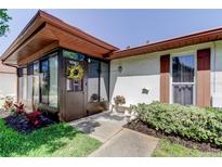 Inviting front entrance with enclosed porch, decorative wreath, and well-maintained landscaping at 2380 Shelly Dr # B, Palm Harbor, FL 34684