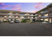Multi-story condo building featuring brick accents, balconies, well-maintained landscaping, and ample parking at 2461 Rhodesian Dr # 37, Clearwater, FL 33763
