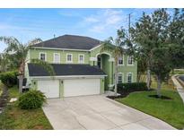 Two-story home with a three-car garage, landscaped yard, and a vibrant green exterior at 2832 Brinley Dr, Trinity, FL 34655