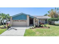 Charming single-story home with a stone facade, well-manicured lawn, and a two-car garage at 3105 Avocet Pl, Safety Harbor, FL 34695