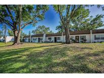 Charming townhomes surrounded by mature trees and a well-maintained lawn offering curb appeal at 3126 Highlands Blvd # 3126, Palm Harbor, FL 34684