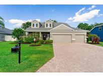 Beautiful home with a brick driveway, well-maintained lawn, lush landscaping, and a two-car garage at 3406 Regner Dr, Plant City, FL 33566