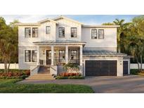 Charming two-story home featuring a covered front porch, a two car garage, and manicured lawn at 530 Severn Ave, Tampa, FL 33606