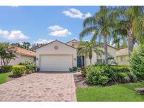 Charming home featuring a paved driveway, lush landscaping, a two-car garage, and well-maintained lawn at 6315 43Rd E Ct, Sarasota, FL 34243