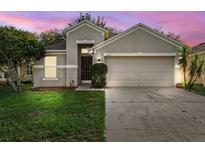 Charming single-story home featuring a well-maintained lawn and an attached two-car garage at 9479 Southern Charm Cir, Brooksville, FL 34613