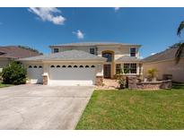 Charming two-story home featuring a three-car garage, landscaped yard, and beautiful architectural details at 10522 Sky Flower Ct, Land O Lakes, FL 34638