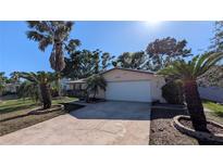 Charming single-story home featuring a two-car garage, well-maintained lawn, and mature palm trees at 1538 S Lake Ave, Clearwater, FL 33756
