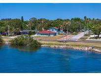 Charming waterfront home boasts a beautiful view, lush landscaping, and inviting curb appeal at 1963 Edgewater Dr, Clearwater, FL 33755