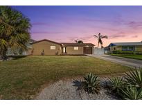 Charming single-story home featuring a well-manicured lawn and mature palm trees at 5108 Commonwealth Rd, Palmetto, FL 34221