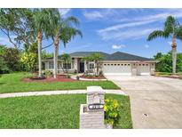 Charming single-story home with manicured lawn, mature trees, and a three-car garage at 6212 Nimes Ct, Lutz, FL 33558
