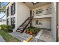 Condo exterior featuring a private entrance with stairs and well-maintained landscaping at 7701 Starkey Rd # 601, Seminole, FL 33777