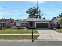 Charming single-story home featuring a well-manicured lawn and a convenient two-car garage at 1948 Citrus Hill Ln, Palm Harbor, FL 34683